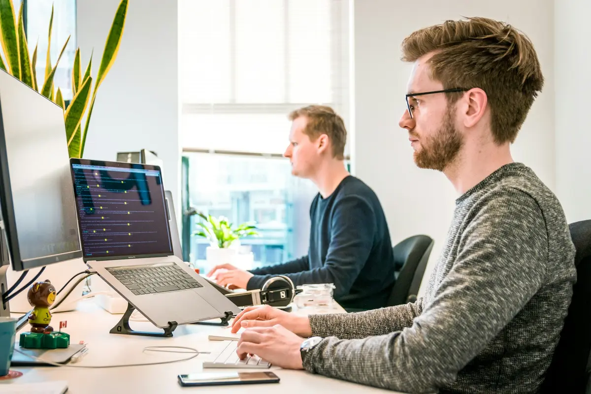 Technician working at a desk with multiple monitors